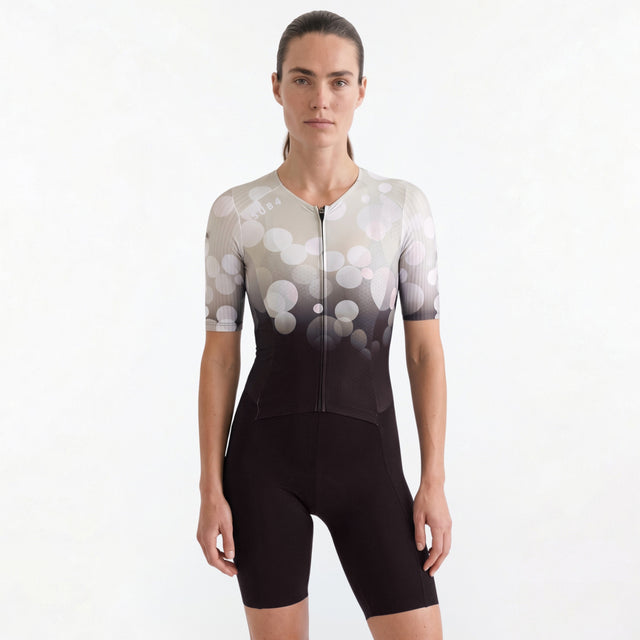 Woman wearing a Triathlon suit with a white and black gradient design on a plain background