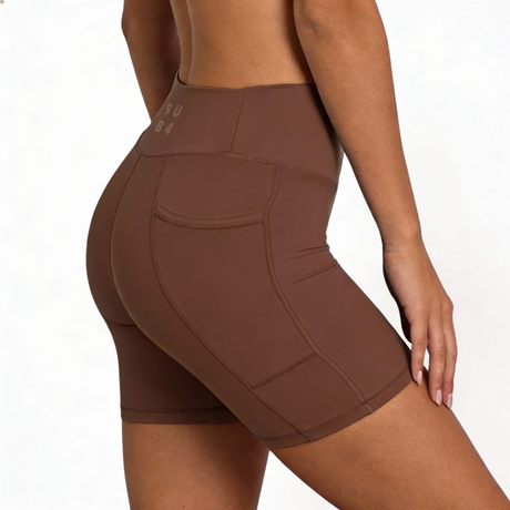 Brown athletic shorts worn by a person on a white background